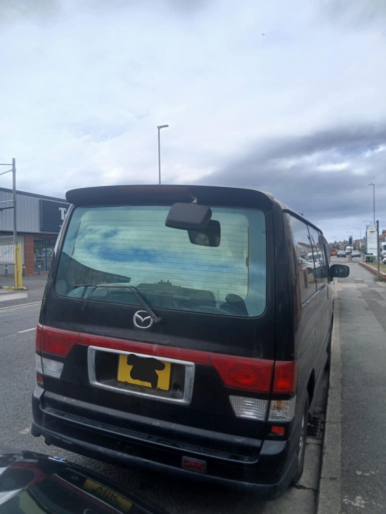 Rear view of a Mazda Bongo campervan with open tailgate, highlighting spacious boot area.