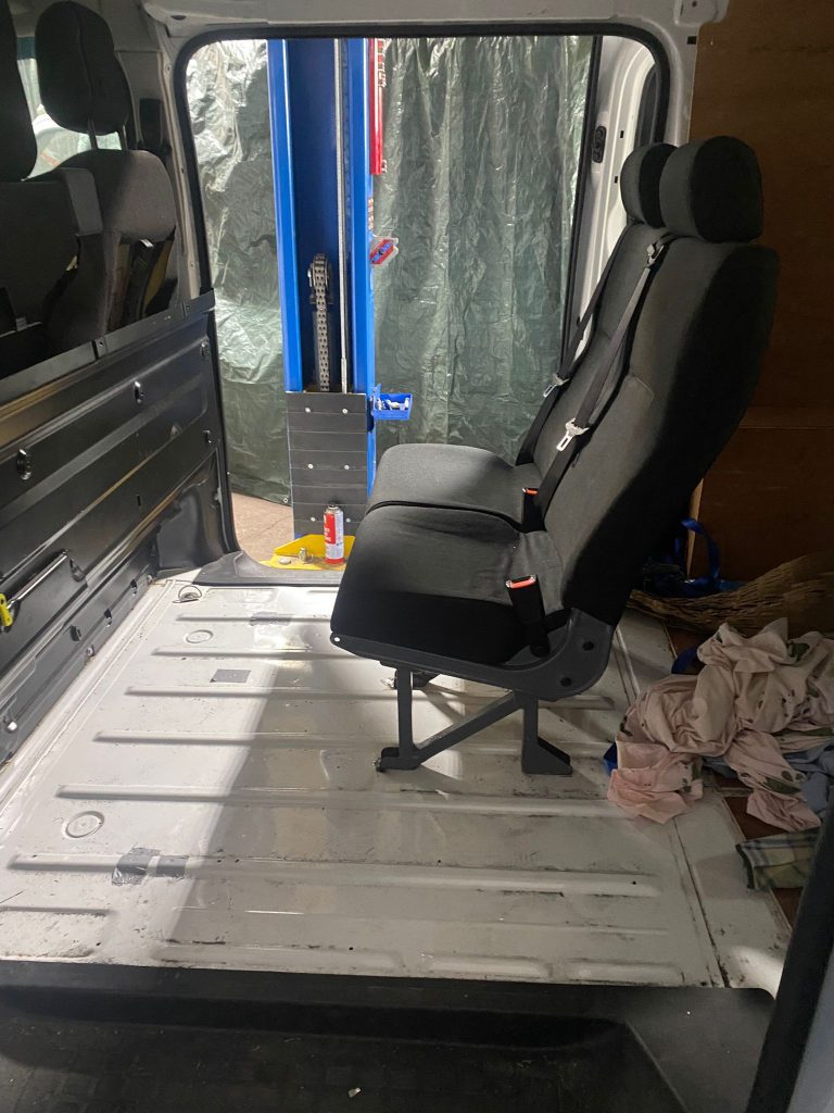 New rear seats installed with seatbelt mounts in a Vauxhall Vivaro conversion”