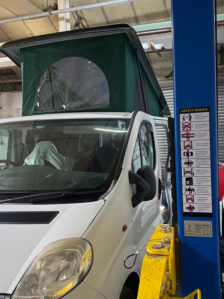 Side angle of the Vauxhall Vivaro with the pop-top roof fully raised during workshop testing