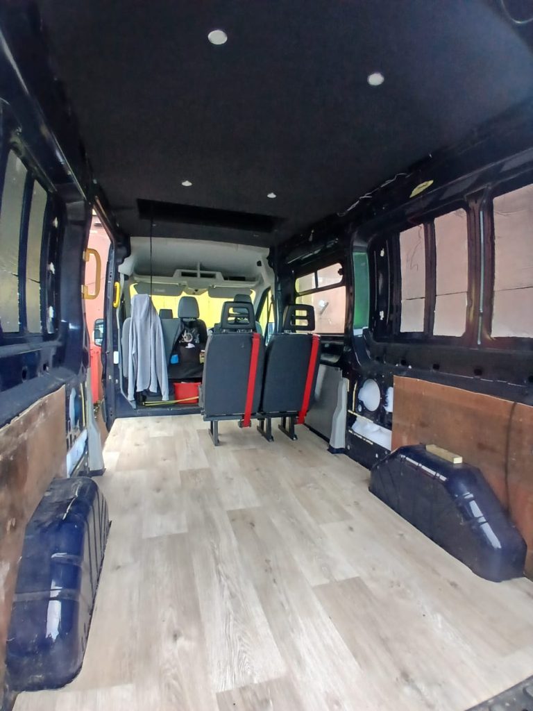 Anthracite carpet-lined bed boards installed within the pop-top of a Ford Transit Custom H2