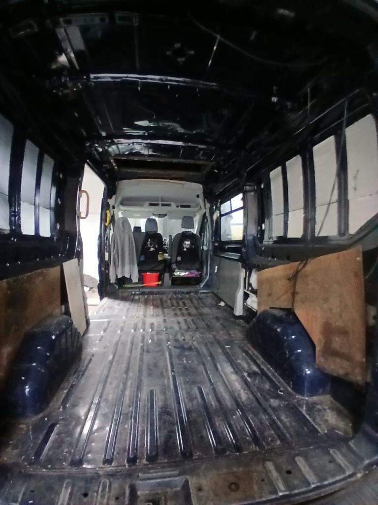 Before Anthracite carpet-lined bed boards installed within the pop-top of a Ford Transit Custom H2
