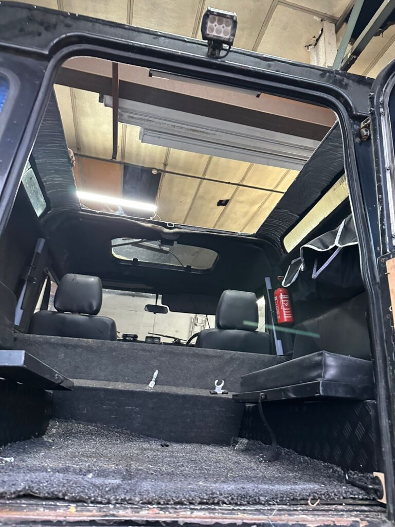 Interior view of Land Rover Defender during pop top roof conversion at Kinmel Campers workshop