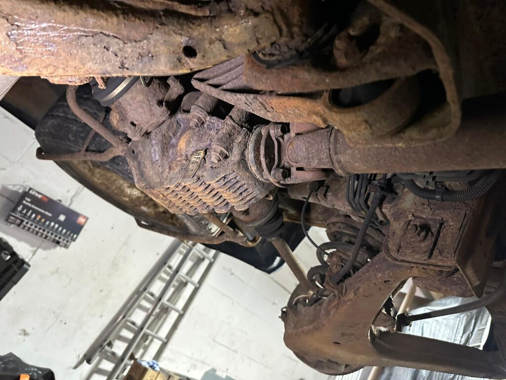 Campervan differential, drivetrain and rear chassis showing surface rust before professional underseal service and corrosion protection