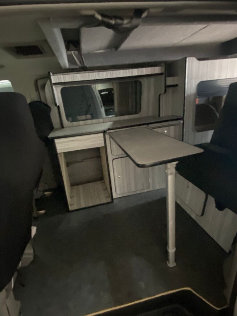 Compact campervan kitchen and storage system in professional van conversion UK
