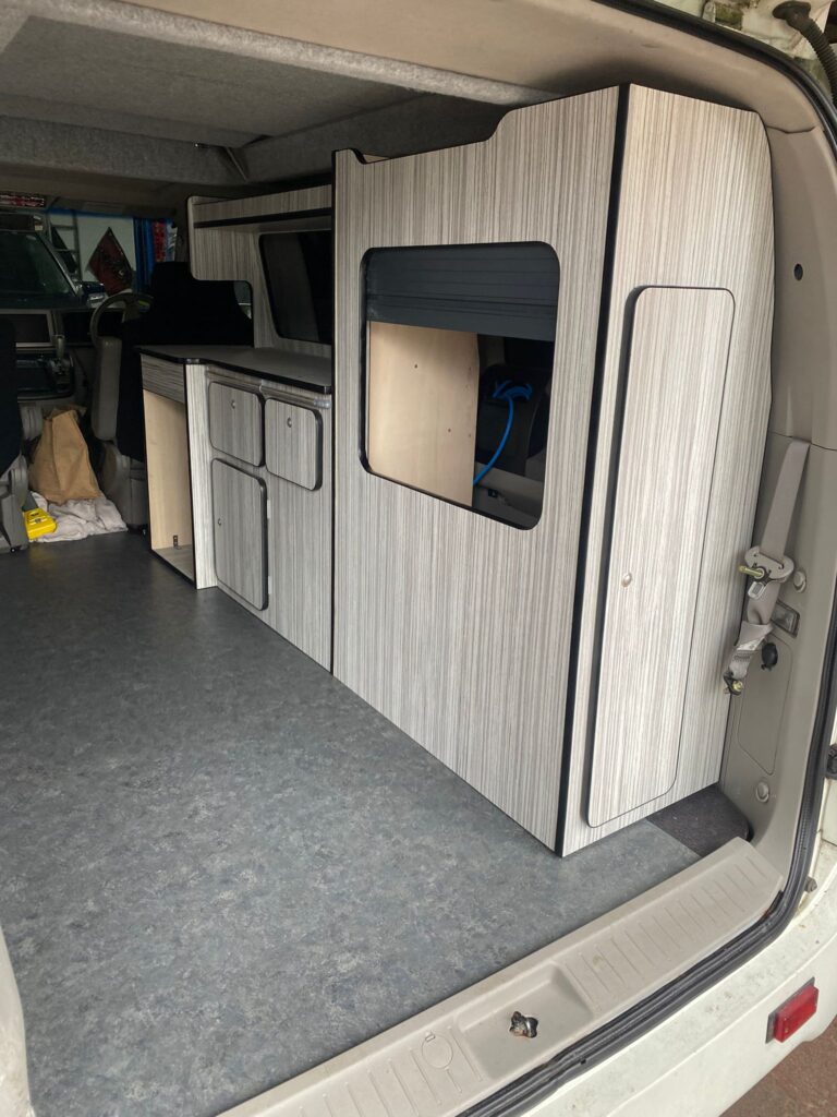 Custom campervan interior build with fitted cabinets and open living space design