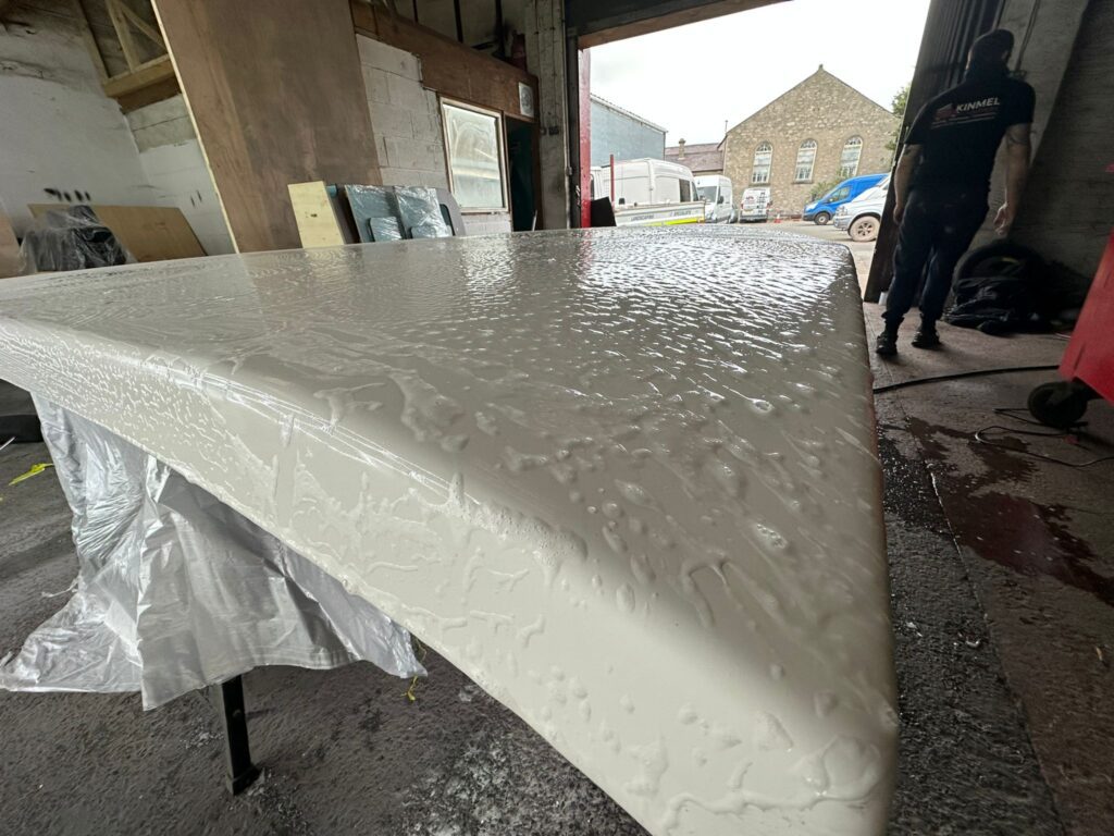 Camper pop top roof surface being detailed and prepped for paint finish during installation process