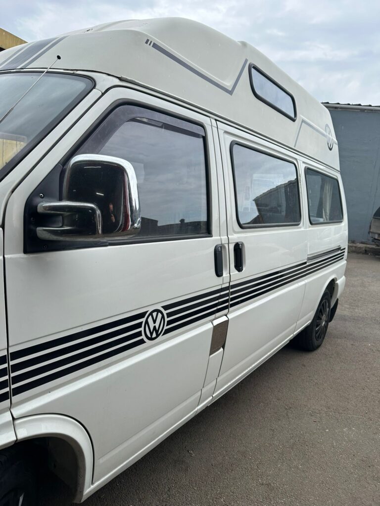 Side profile of classic VW T4 campervan undergoing mechanical servicing at Kinmel Campers
