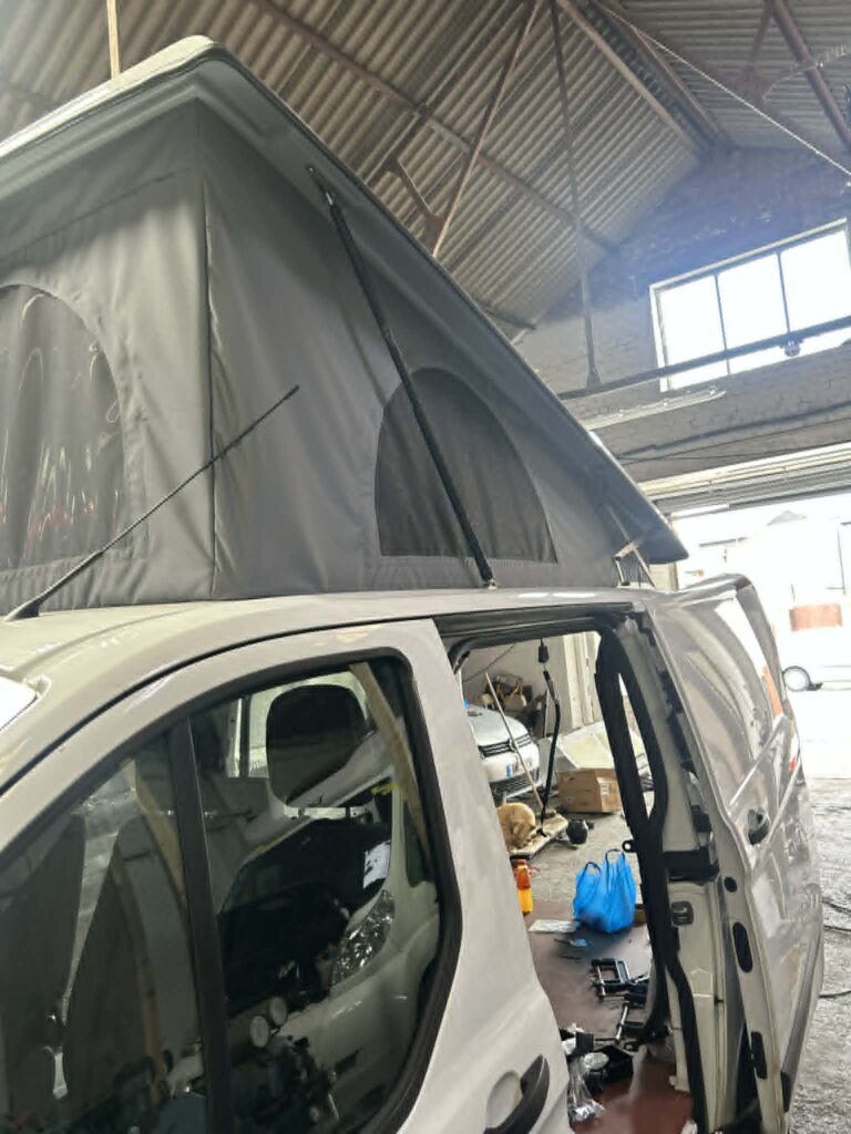 Side view of bi-fold bed platform fitted inside Ford Transit Custom elevating roof conversion