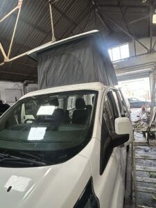Ford Transit Custom pop top roof installation with integrated bi-fold bed completed in North Wales