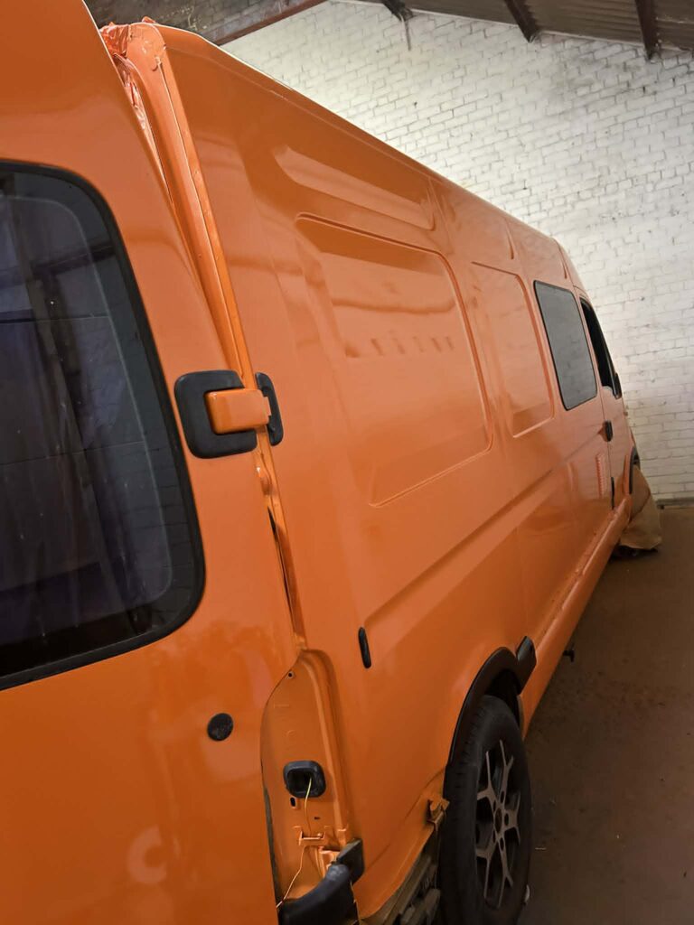 Side view of bright orange campervan after full respray and bodywork repairs